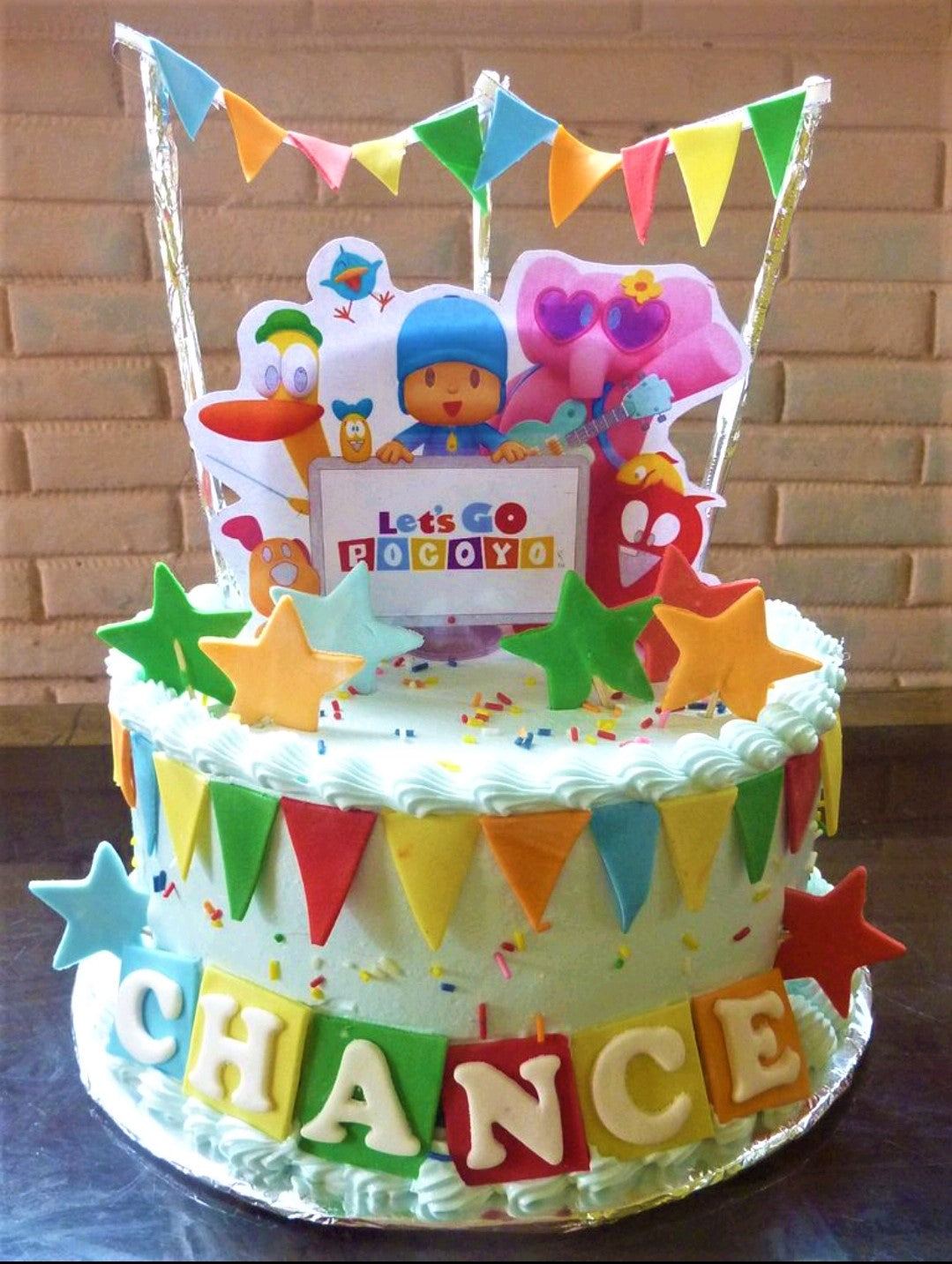 Light blue Pocoyo themed birthday cake with colorful bunting, stars, and character printouts for Chance's birthday. Light blue Pocoyo themed birthday cake with colorful bunting, stars, and character printouts for Chance's birthday.