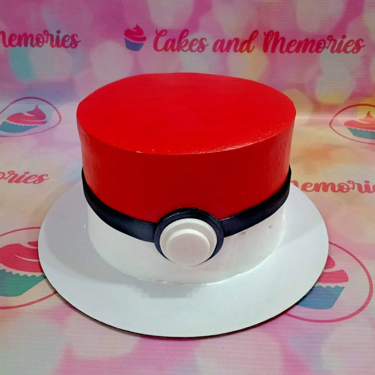 Pokeball Birthday Cake A red, white, and black 1 Tier cake themed around Pokeball, featuring a black fondant band and a white circular button.