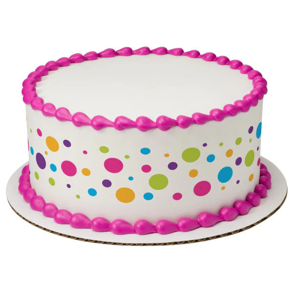 White round birthday cake with colorful polka dots and bright pink icing borders on top and base. White round birthday cake with colorful polka dots and bright pink icing borders on top and base.