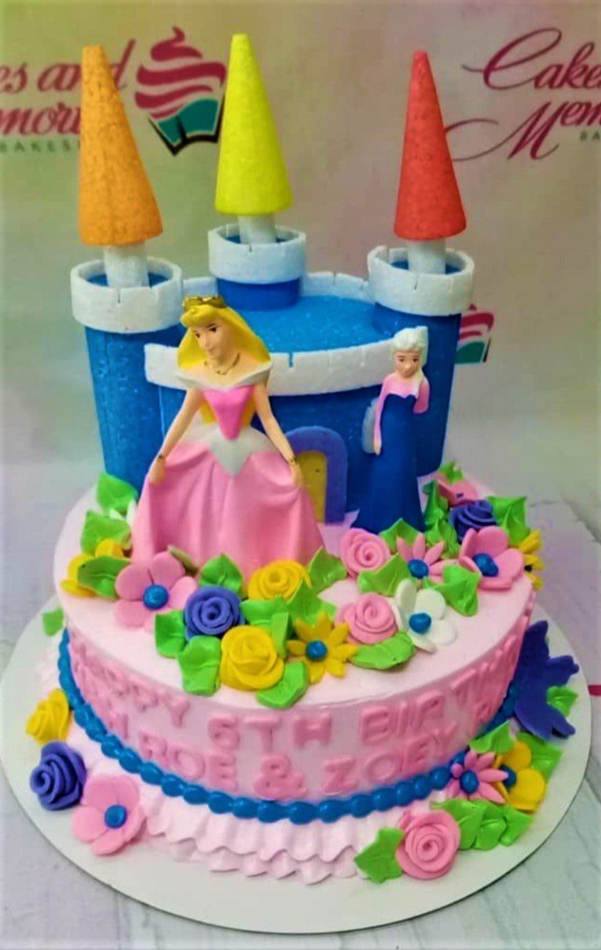 Pink princess castle cake with Aurora and Elsa figurines, colorful fondant flowers, and blue castle topper. Pink princess castle cake with Aurora and Elsa figurines, colorful fondant flowers, and blue castle topper.