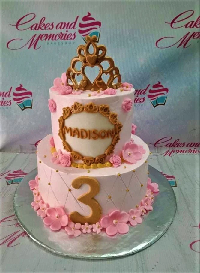 Princess Pink Floral 2-Tier Cake Pink 2-tier princess cake with a gold crown topper, pink fondant flowers, and a gold number 3.