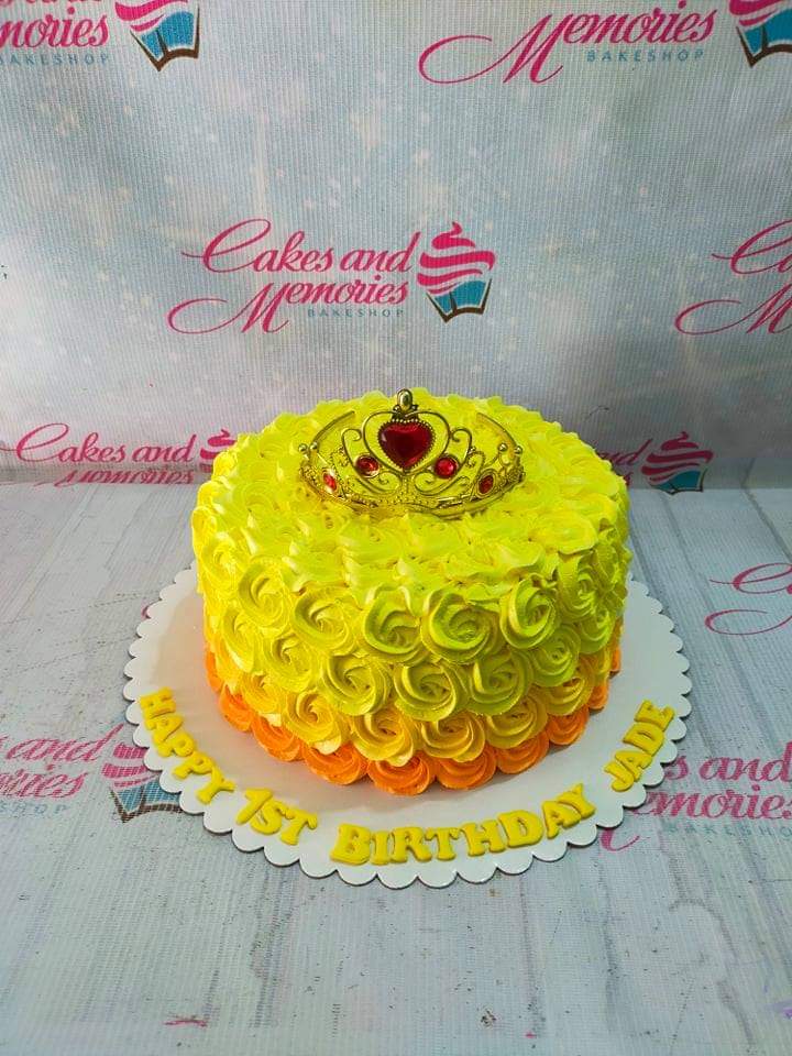 Yellow and orange ombre rosette cake with a gold rhinestone crown topper and yellow icing message on the base board. Yellow and orange ombre rosette cake with a gold rhinestone crown topper and yellow icing message on the base board.