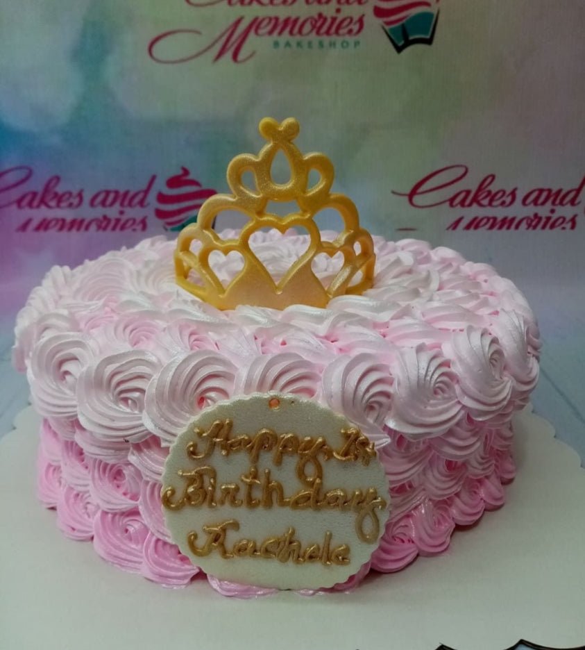 Pink rosette soft-icing cake with a gold tiara topper and a personalized birthday message on a white plaque. Pink rosette soft-icing cake with a gold tiara topper and a personalized birthday message on a white plaque.