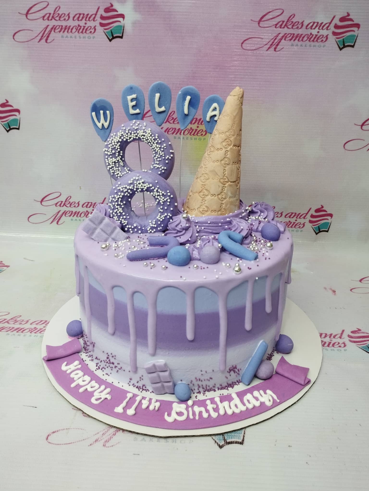 Purple ombre drip cake with a large number 8 topper, ice cream cone, and purple candy decorations. Purple ombre drip cake with a large number 8 topper, ice cream cone, and purple candy decorations.