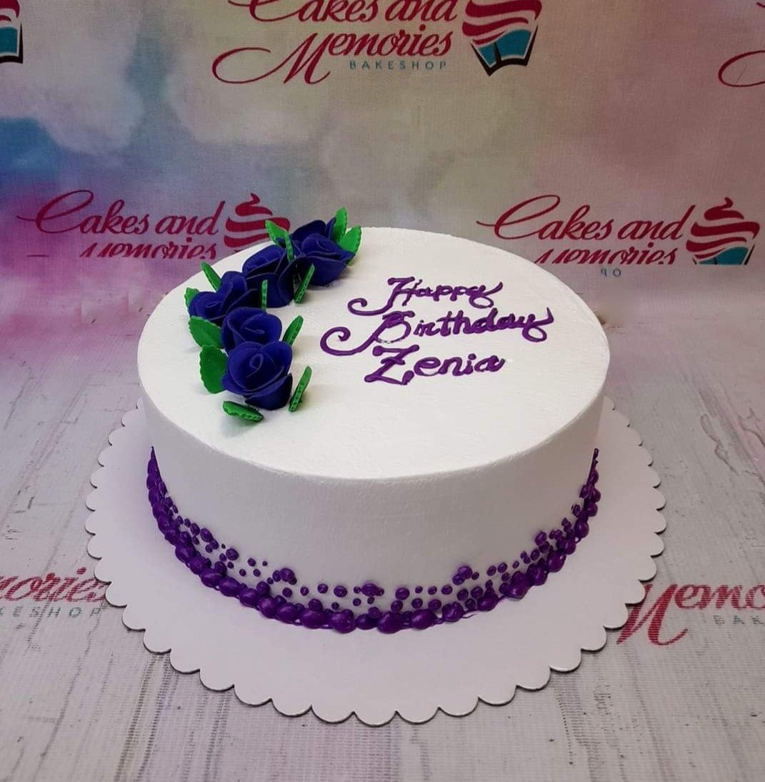 White minimalist birthday cake with deep purple roses and purple icing text for Zenia. White minimalist birthday cake with deep purple roses and purple icing text for Zenia.