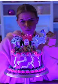 Purple neon themed birthday cake with character printouts and lightning bolt designs under UV light. Purple neon themed birthday cake with character printouts and lightning bolt designs under UV light.