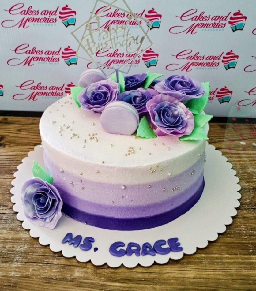 Purple ombre birthday cake with purple roses, macarons, and a silver Happy Birthday topper. Purple ombre birthday cake with purple roses, macarons, and a silver Happy Birthday topper.