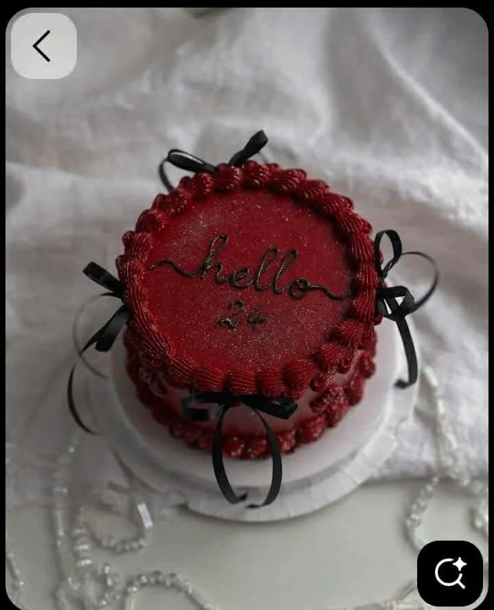 Red coquette cake design — 1 layer soft icing cake in red — with black bows, red shell borders, and custom "hello 24" message
