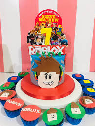 Roblox themed birthday cake for Steve Mathew with blue icing, character printouts, and matching cupcakes. Roblox themed birthday cake for Steve Mathew with blue icing, character printouts, and matching cupcakes.