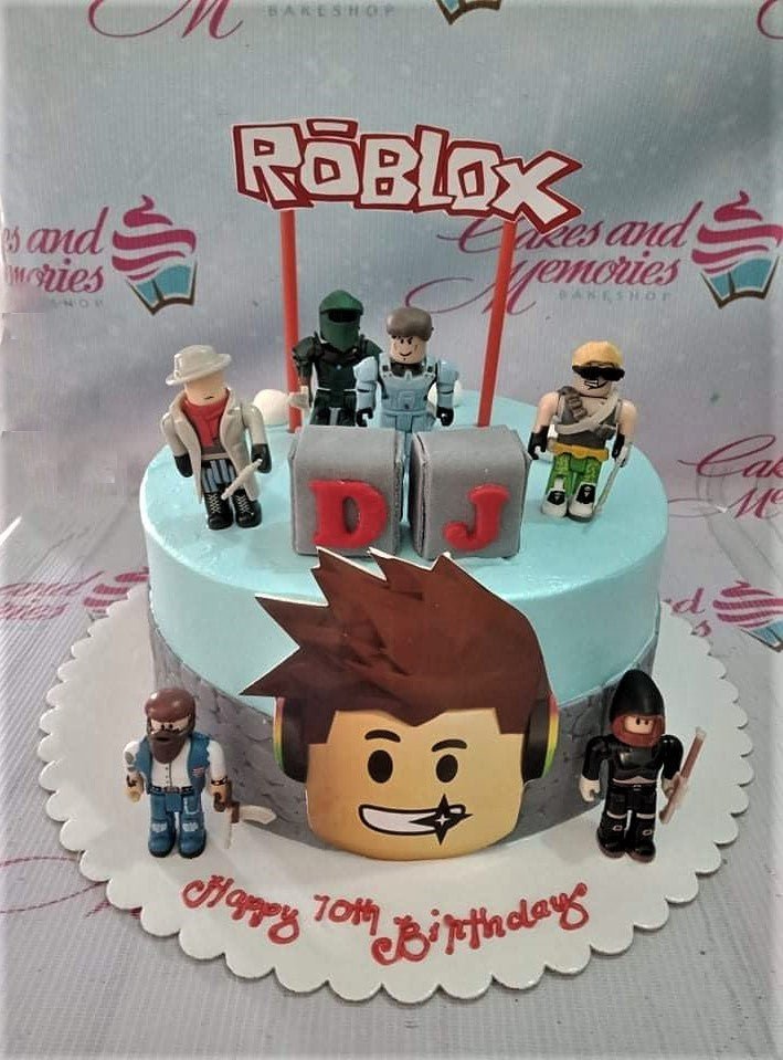 Light blue Roblox themed birthday cake with 3D character figures and a large Roblox logo topper. Light blue Roblox themed birthday cake with 3D character figures and a large Roblox logo topper.