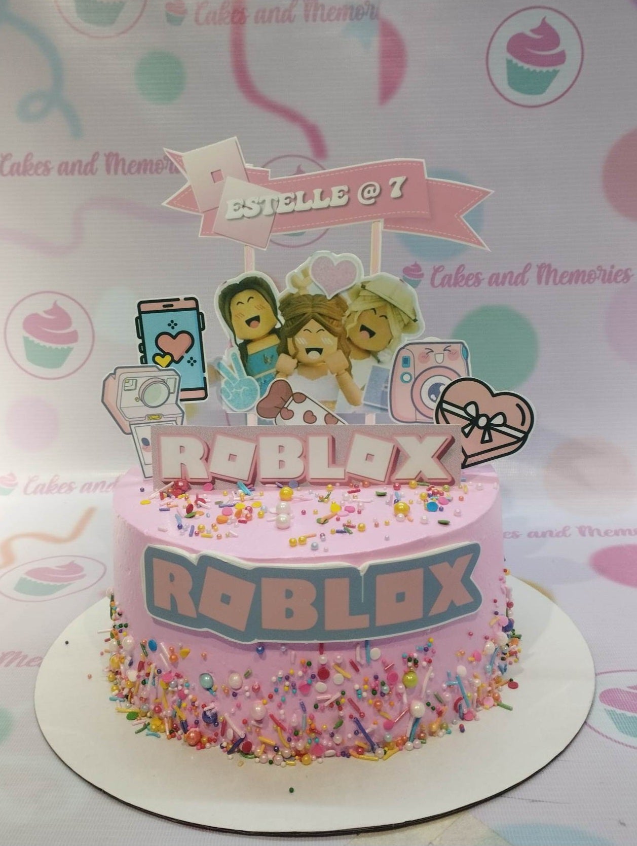Pink Roblox themed birthday cake for Estelle's 7th birthday with character printouts and colorful sprinkles. Pink Roblox themed birthday cake for Estelle's 7th birthday with character printouts and colorful sprinkles.
