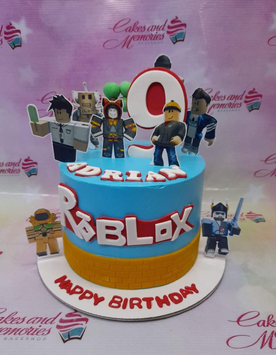 Blue Roblox themed birthday cake with character printouts, a large number 9 topper, and a yellow brick-patterned base. Blue Roblox themed birthday cake with character printouts, a large number 9 topper, and a yellow brick-patterned base.