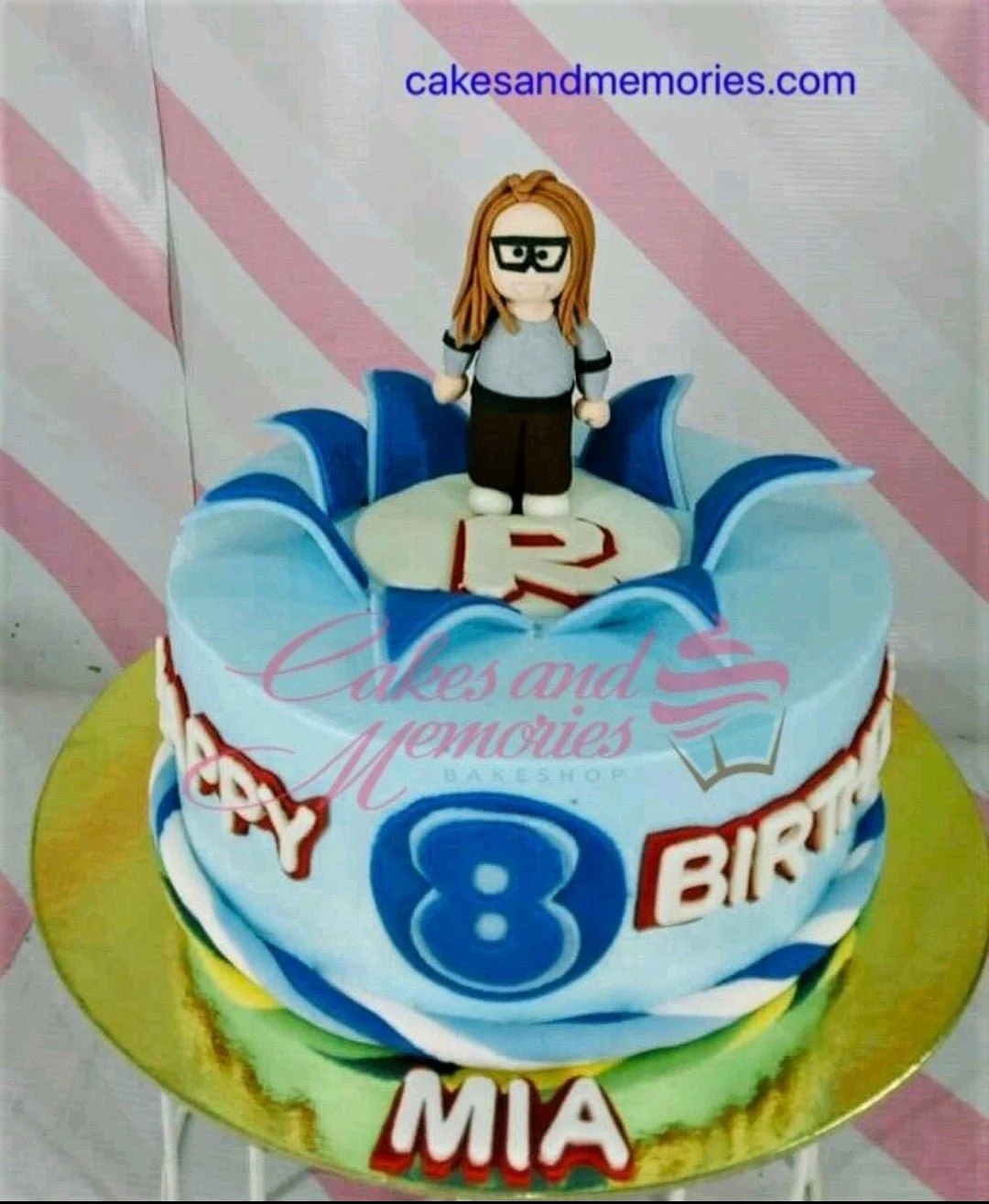 Roblox-Inspired Sky Blue Birthday Cake Blue Roblox themed birthday cake with a custom 3D fondant character topper and the name Mia.