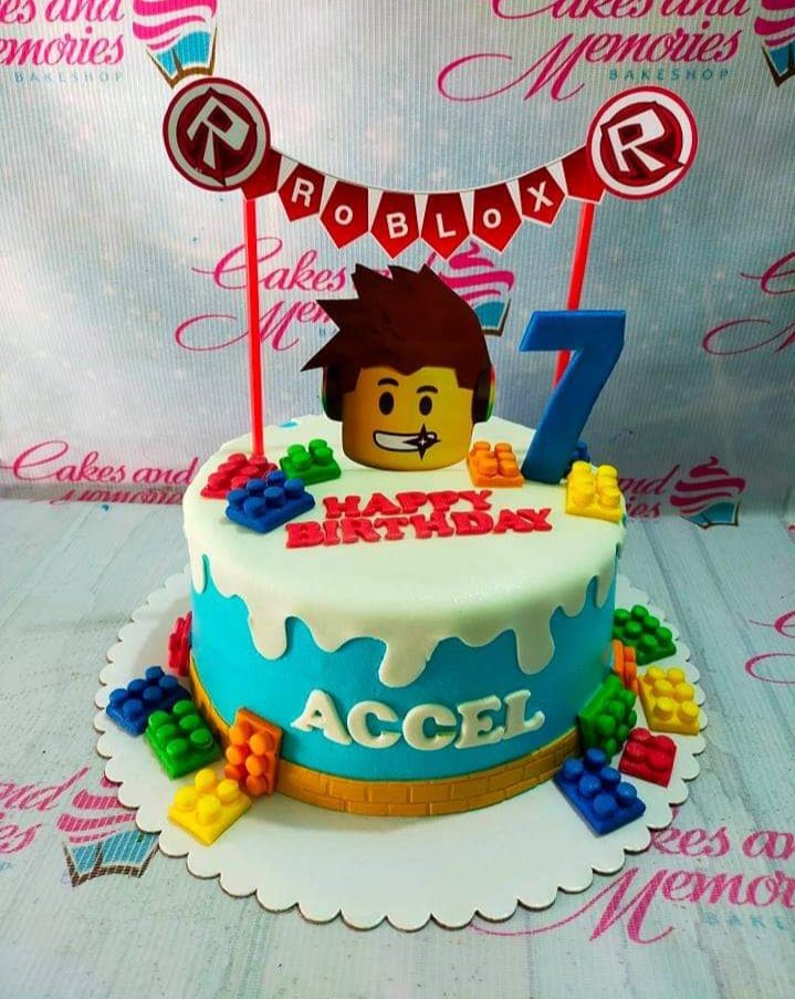 Roblox themed birthday cake for Accel featuring a 3D character topper, lego brick decorations, and a blue fondant base with white drip. Roblox themed birthday cake for Accel featuring a 3D character topper, lego brick decorations, and a blue fondant base with white drip.