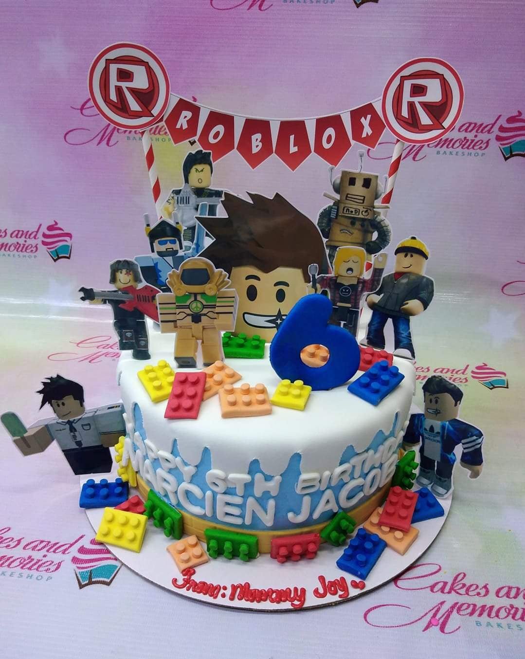 Roblox themed birthday cake with blue and white fondant icing, edible lego bricks, and various character printouts for a 6th birthday. Roblox themed birthday cake with blue and white fondant icing, edible lego bricks, and various character printouts for a 6th birthday.