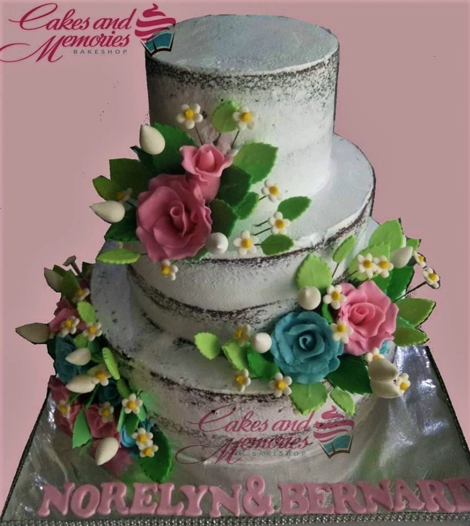 3-tier semi-naked rustic cake with pink and teal gumpaste roses, white filler flowers, and pink gumpaste name letters on the base board.