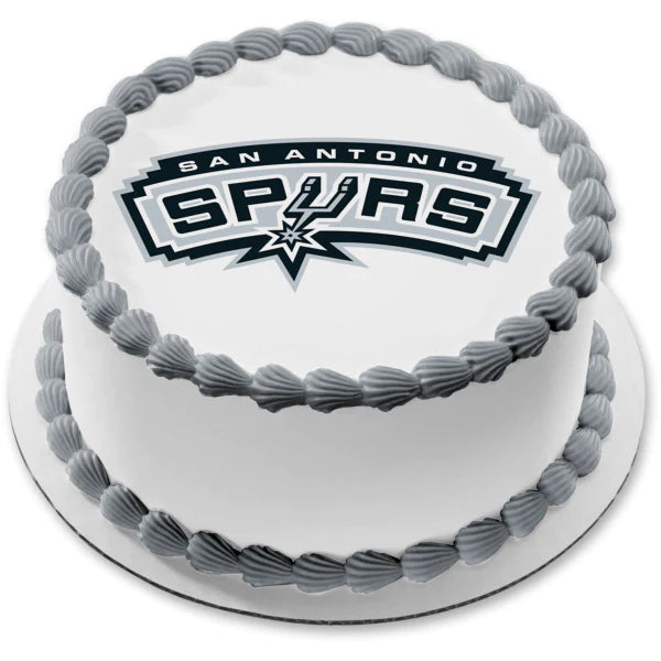 White round cake with gray shell borders and a large San Antonio Spurs logo printout on top. White round cake with gray shell borders and a large San Antonio Spurs logo printout on top.