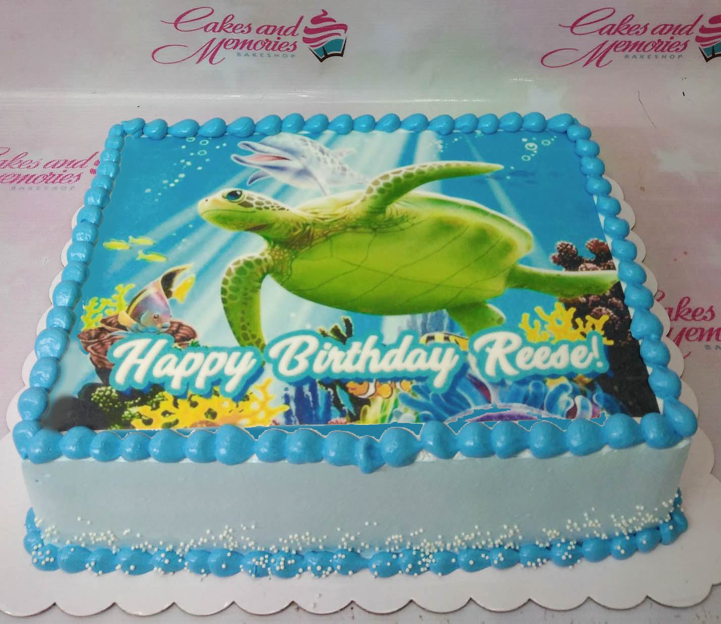 Light blue rectangular sea turtle birthday cake with edible photo print and blue icing borders