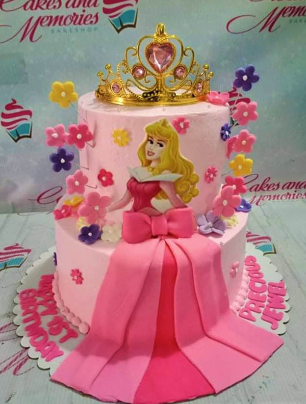 Pink 2-tier Sleeping Beauty Aurora cake with a gold crown, pink fondant bow, and colorful gumpaste flowers. Pink 2-tier Sleeping Beauty Aurora cake with a gold crown, pink fondant bow, and colorful gumpaste flowers.