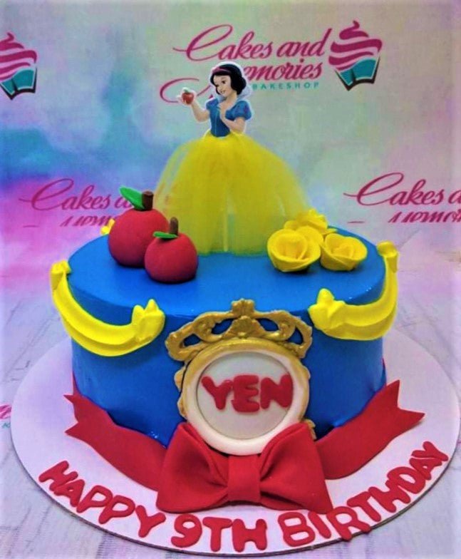 Blue Snow White themed birthday cake with a Snow White printout topper, red fondant apples, and yellow icing roses. Blue Snow White themed birthday cake with a Snow White printout topper, red fondant apples, and yellow icing roses.