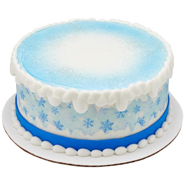 Blue and white snowflake themed cake with white icing ruffles and a blue snowflake pattern on the side. Blue and white snowflake themed cake with white icing ruffles and a blue snowflake pattern on the side.