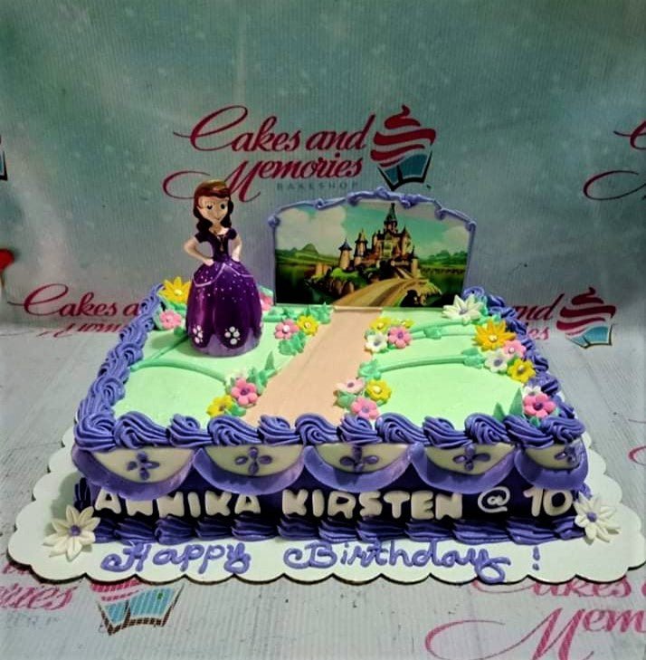 Sofia the First themed rectangle cake with purple icing ruffles, a Sofia figurine, and a castle printout backdrop. Sofia the First themed rectangle cake with purple icing ruffles, a Sofia figurine, and a castle printout backdrop.