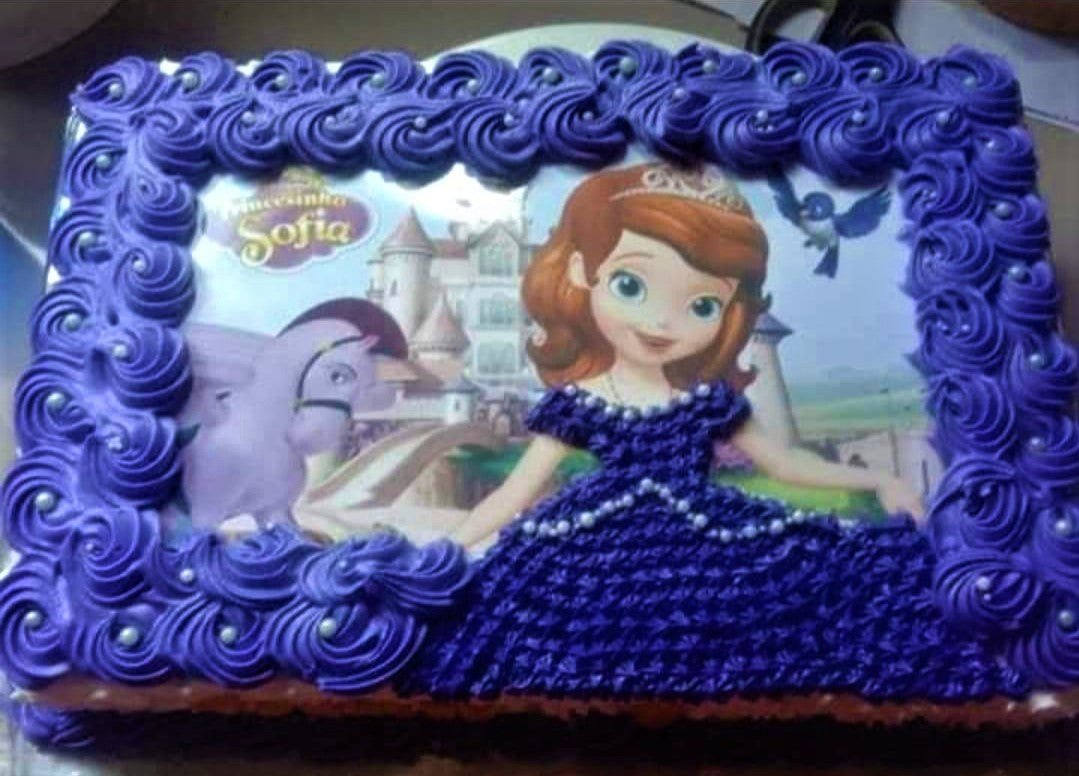 Sofia the First themed rectangle cake with purple icing rosettes and a printed character image. Sofia the First themed rectangle cake with purple icing rosettes and a printed character image.