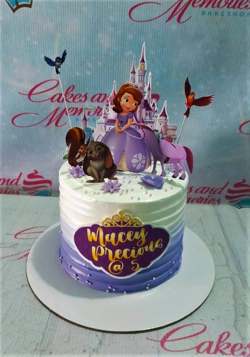 Sofia the First themed purple and white gradient cake with character printouts and a castle backdrop. Sofia the First themed purple and white gradient cake with character printouts and a castle backdrop.