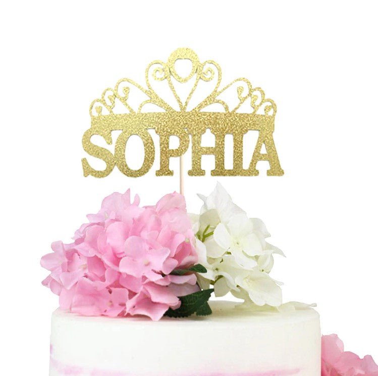 White minimalist cake with a gold glitter Sophia crown topper and pink and white hydrangea flowers. White minimalist cake with a gold glitter Sophia crown topper and pink and white hydrangea flowers.