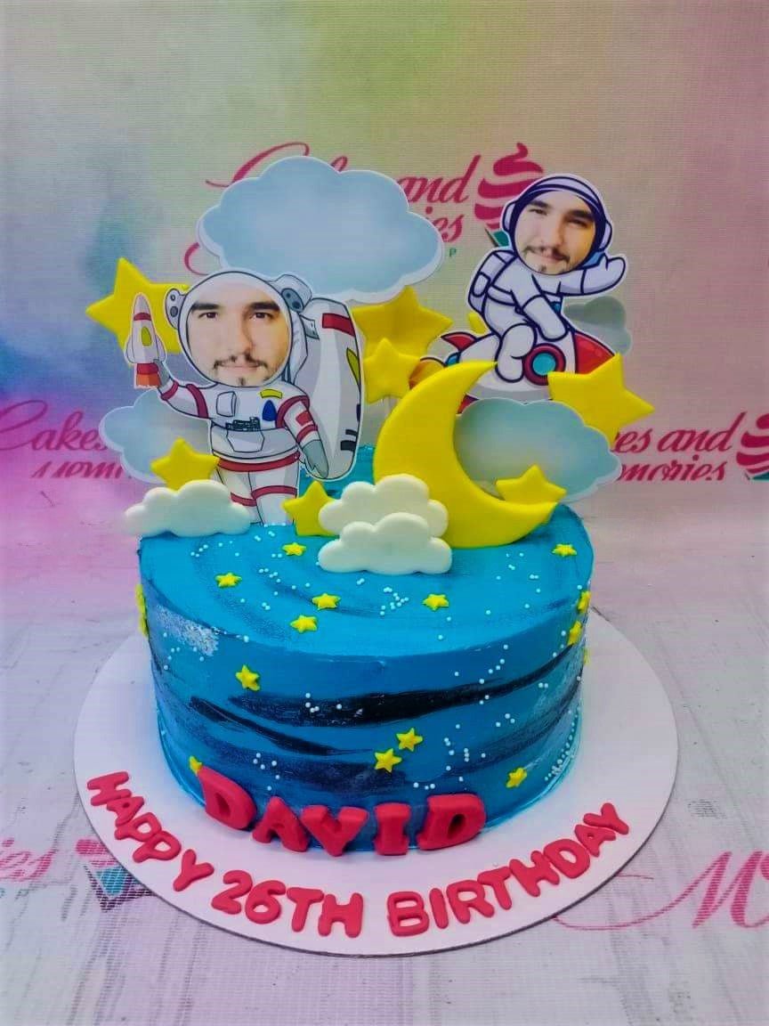 Blue space themed birthday cake with astronaut printouts, yellow moon and stars, and red gumpaste letters for David's 26th birthday. Blue space themed birthday cake with astronaut printouts, yellow moon and stars, and red gumpaste letters for David's 26th birthday.