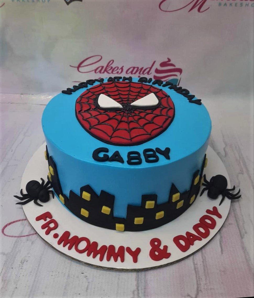 Blue Spiderman birthday cake with a large red Spiderman face topper, black city skyline silhouette, and black spiders on the base board. Blue Spiderman birthday cake with a large red Spiderman face topper, black city skyline silhouette, and black spiders on the base board.
