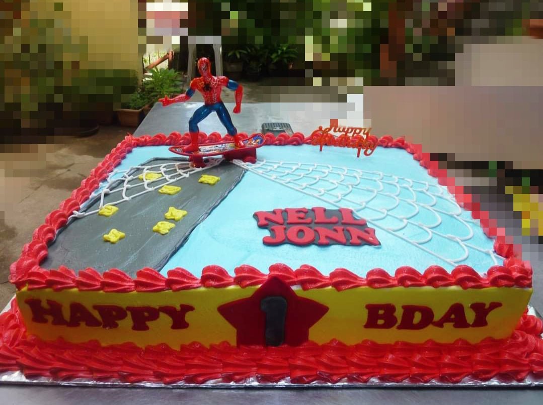 Spiderman themed rectangle cake with a Spiderman toy on a skateboard, web icing, and red piped borders on yellow and blue icing. Spiderman themed rectangle cake with a Spiderman toy on a skateboard, web icing, and red piped borders on yellow and blue icing.
