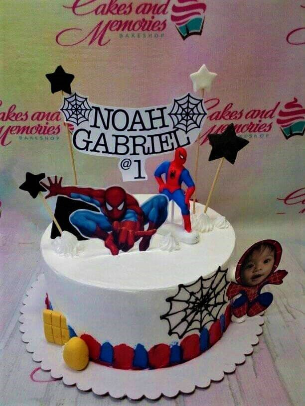 Spiderman themed birthday cake with white icing, red and blue border, and various Spiderman character printouts and star toppers. Spiderman themed birthday cake with white icing, red and blue border, and various Spiderman character printouts and star toppers.
