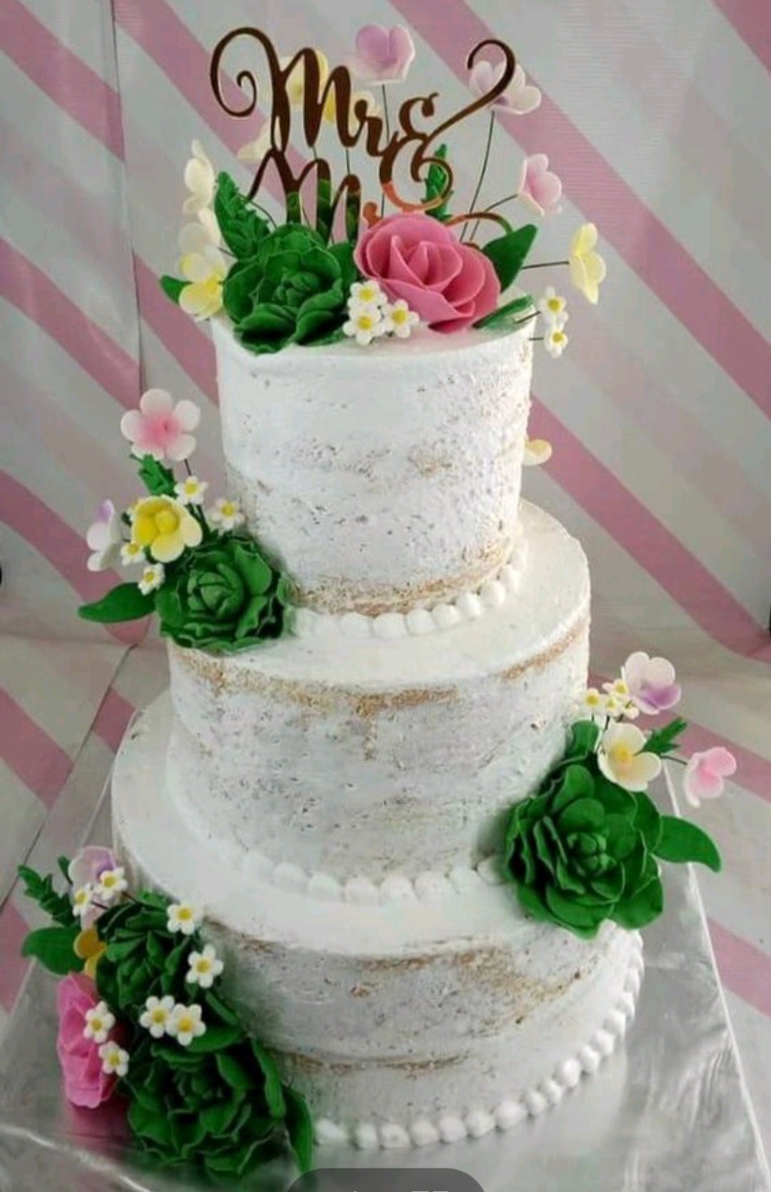 Three-tier semi-naked wedding cake decorated with green and pink gumpaste succulents and flowers with a gold Mr & Mrs topper. Three-tier semi-naked wedding cake decorated with green and pink gumpaste succulents and flowers with a gold Mr & Mrs topper.