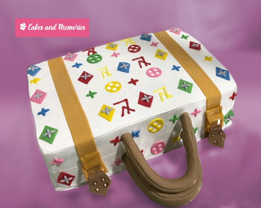 White rectangular suitcase cake with colorful Louis Vuitton inspired monogram patterns and brown fondant handle and straps. White rectangular suitcase cake with colorful Louis Vuitton inspired monogram patterns and brown fondant handle and straps.