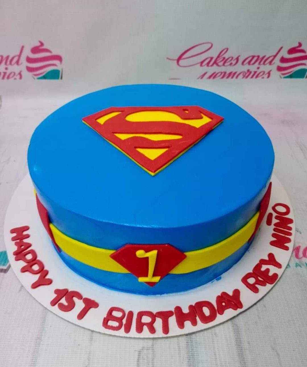 Blue Superman themed fondant cake with red and yellow logo and belt design for a 1st birthday celebration. Blue Superman themed fondant cake with red and yellow logo and belt design for a 1st birthday celebration.