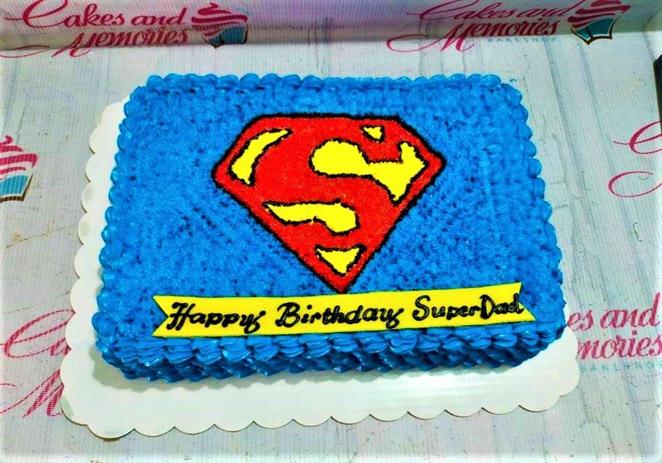 Blue Superman themed rectangle cake with a large red and yellow Superman logo and a yellow birthday banner. Blue Superman themed rectangle cake with a large red and yellow Superman logo and a yellow birthday banner.