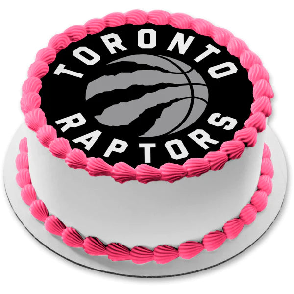 White round cake with pink icing borders and a large Toronto Raptors logo printout on top. White round cake with pink icing borders and a large Toronto Raptors logo printout on top.