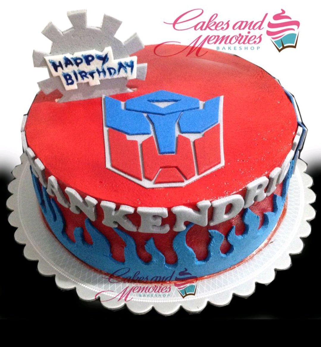 Red Transformers themed birthday cake with blue flame icing and Autobot logo topper Red Transformers themed birthday cake with blue flame icing and Autobot logo topper