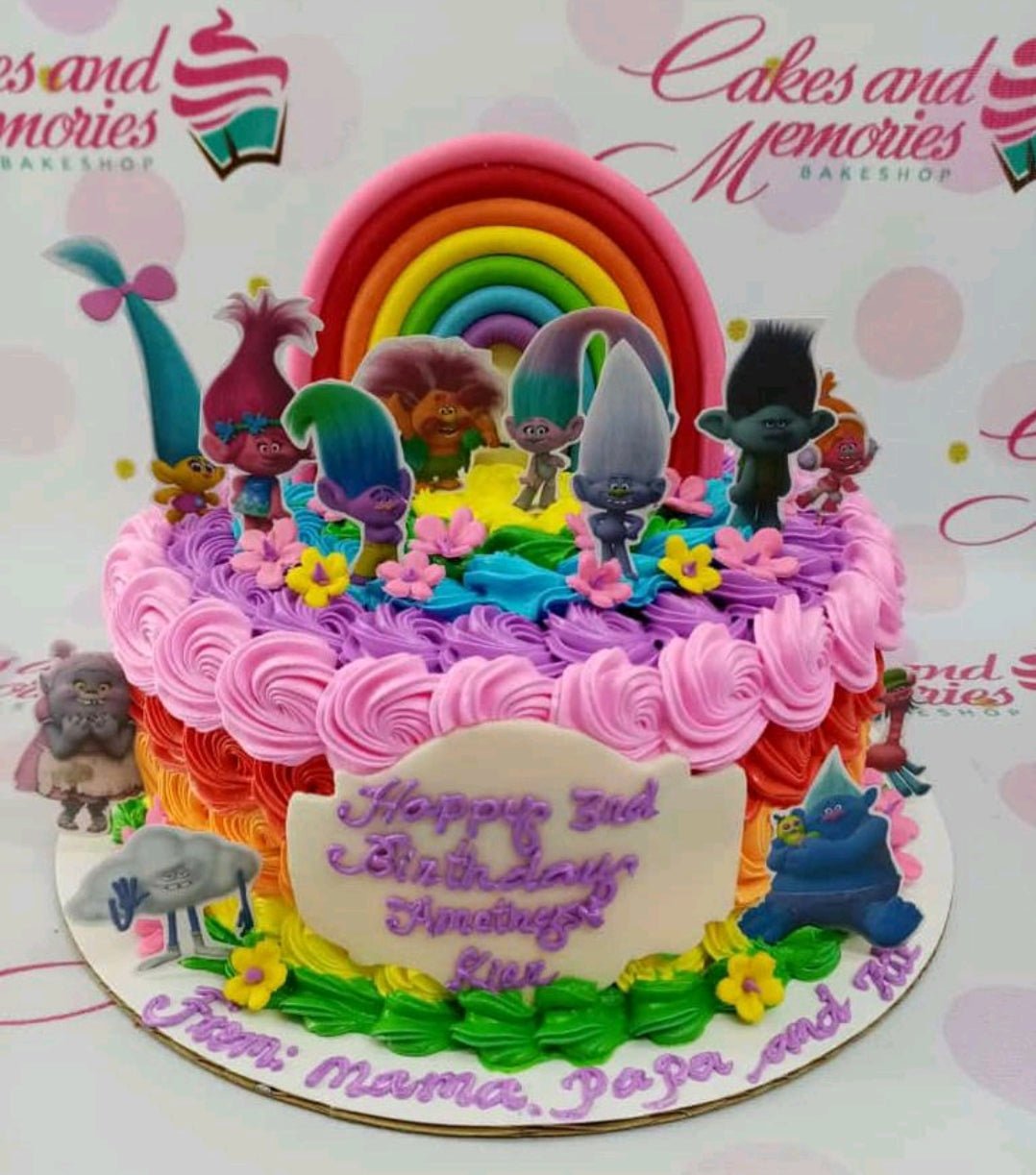 Rainbow Trolls birthday cake with colorful icing rosettes, a fondant rainbow, and character printouts. Rainbow Trolls birthday cake with colorful icing rosettes, a fondant rainbow, and character printouts.