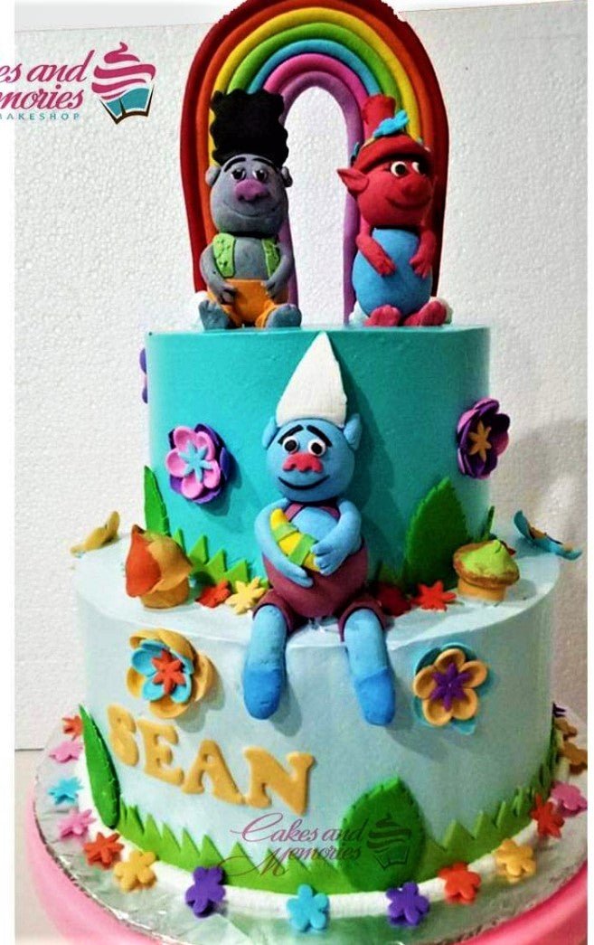 Two-tier Trolls themed birthday cake in teal and light blue fondant with edible 3D figures of Guy Diamond, Branch, and Poppy. Two-tier Trolls themed birthday cake in teal and light blue fondant with edible 3D figures of Guy Diamond, Branch, and Poppy.