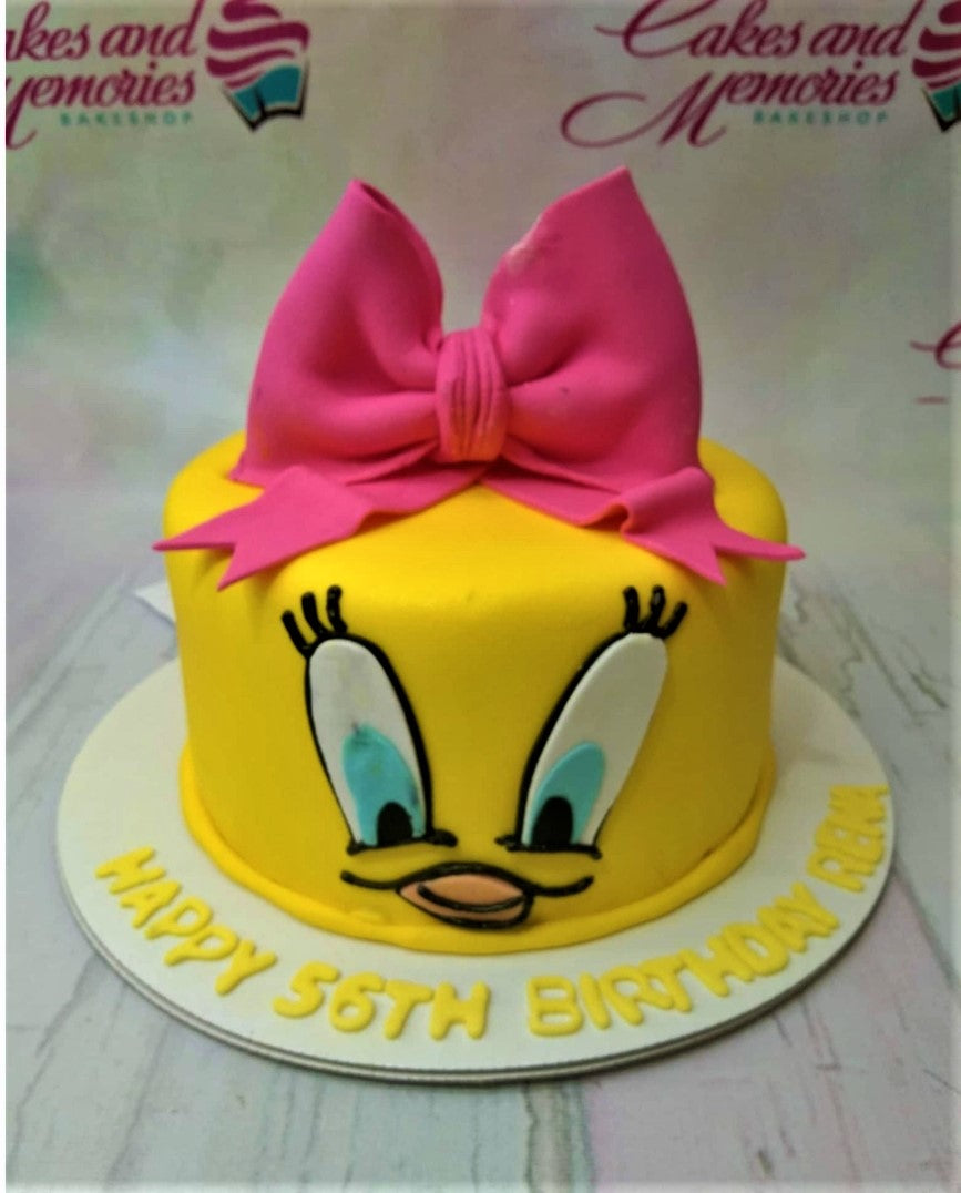Yellow Tweety Bird character cake with a large pink fondant bow and birthday message on the base board. Yellow Tweety Bird character cake with a large pink fondant bow and birthday message on the base board.