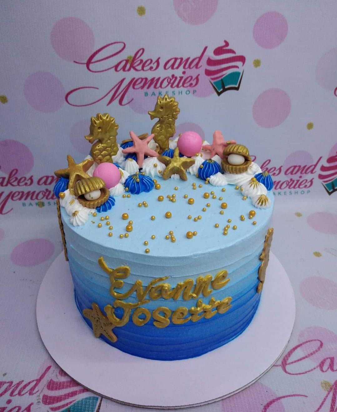Under the sea themed blue gradient cake with gold seahorses, pink starfish, and golden shells with pearls. Under the sea themed blue gradient cake with gold seahorses, pink starfish, and golden shells with pearls.