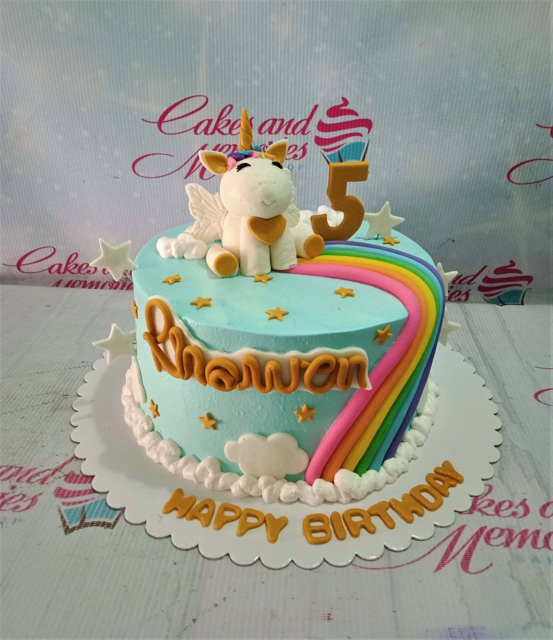 Light blue unicorn birthday cake with a 3D fondant unicorn, rainbow, gold stars, and white clouds. Light blue unicorn birthday cake with a 3D fondant unicorn, rainbow, gold stars, and white clouds.