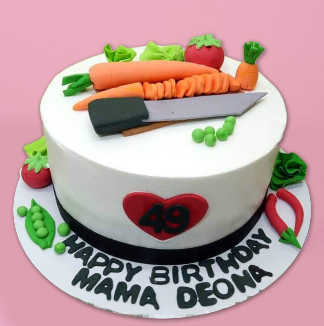 White round cake with fondant vegetable toppers including carrots, tomatoes, peas, and a chef knife for a 49th birthday. White round cake with fondant vegetable toppers including carrots, tomatoes, peas, and a chef knife for a 49th birthday.