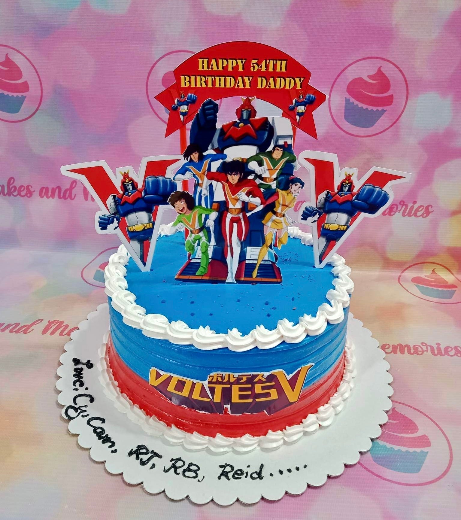 Voltes V themed birthday cake with blue and red icing, white piped borders, and character printouts for a 54th birthday. Voltes V themed birthday cake with blue and red icing, white piped borders, and character printouts for a 54th birthday.