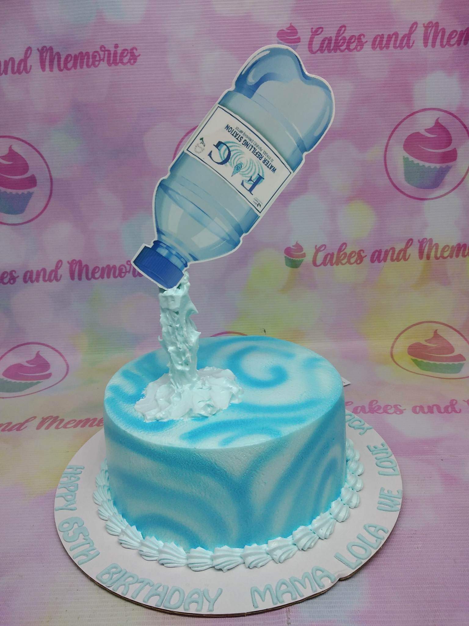 Light blue and white swirl icing cake with a large water bottle printout topper pouring out white icing water. Light blue and white swirl icing cake with a large water bottle printout topper pouring out white icing water.