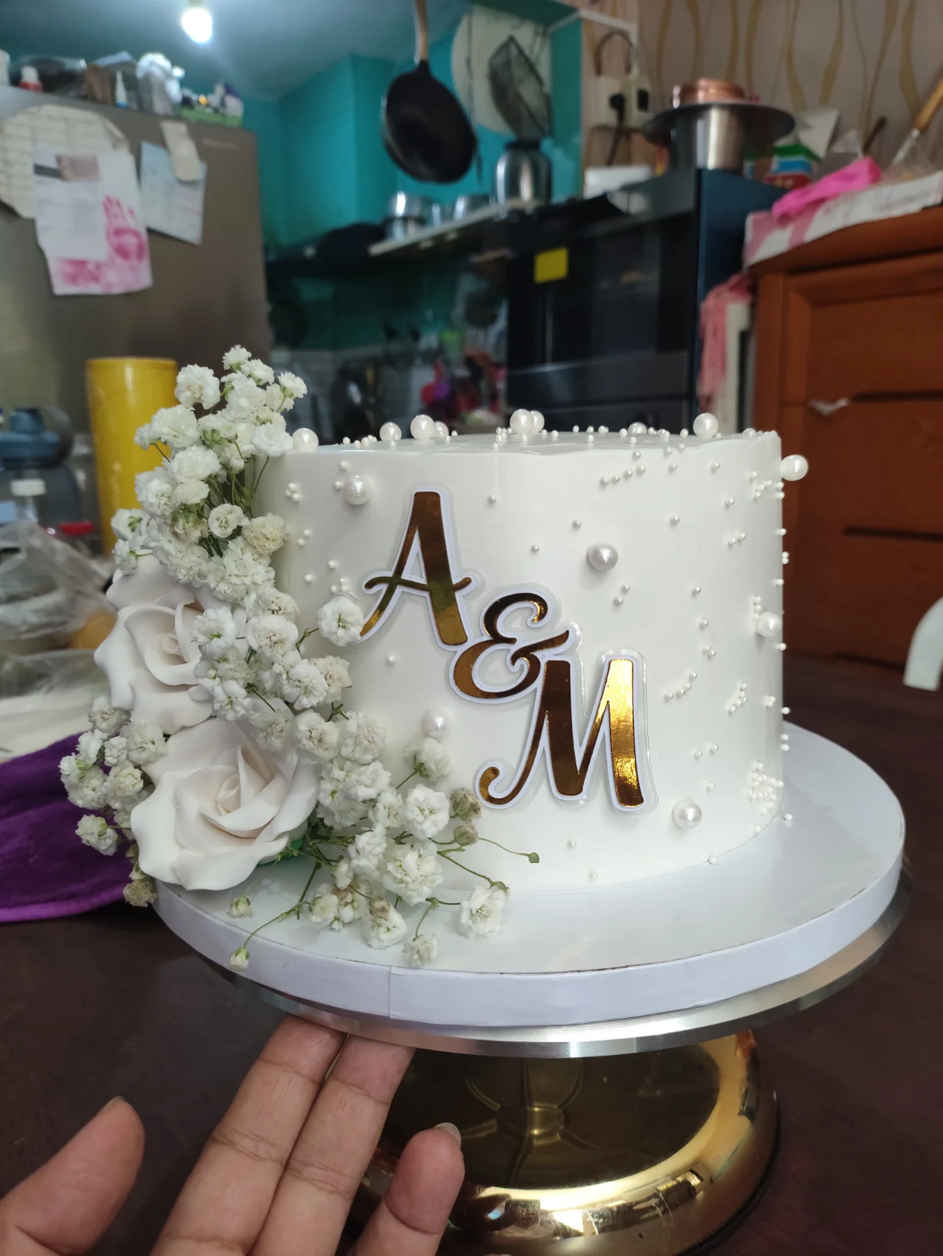 White minimalist cake with fresh white roses, baby's breath, and gold A&M initials White minimalist cake with fresh white roses, baby's breath, and gold A&M initials