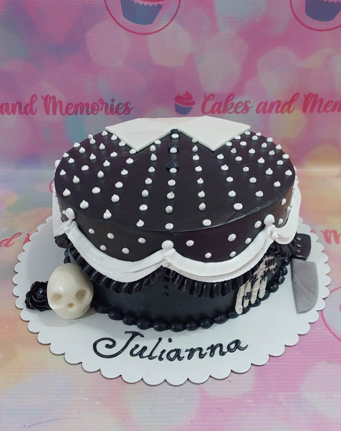 Black Wednesday Addams inspired cake with white polka dots, white collar, skull, and knife decorations. Black Wednesday Addams inspired cake with white polka dots, white collar, skull, and knife decorations.