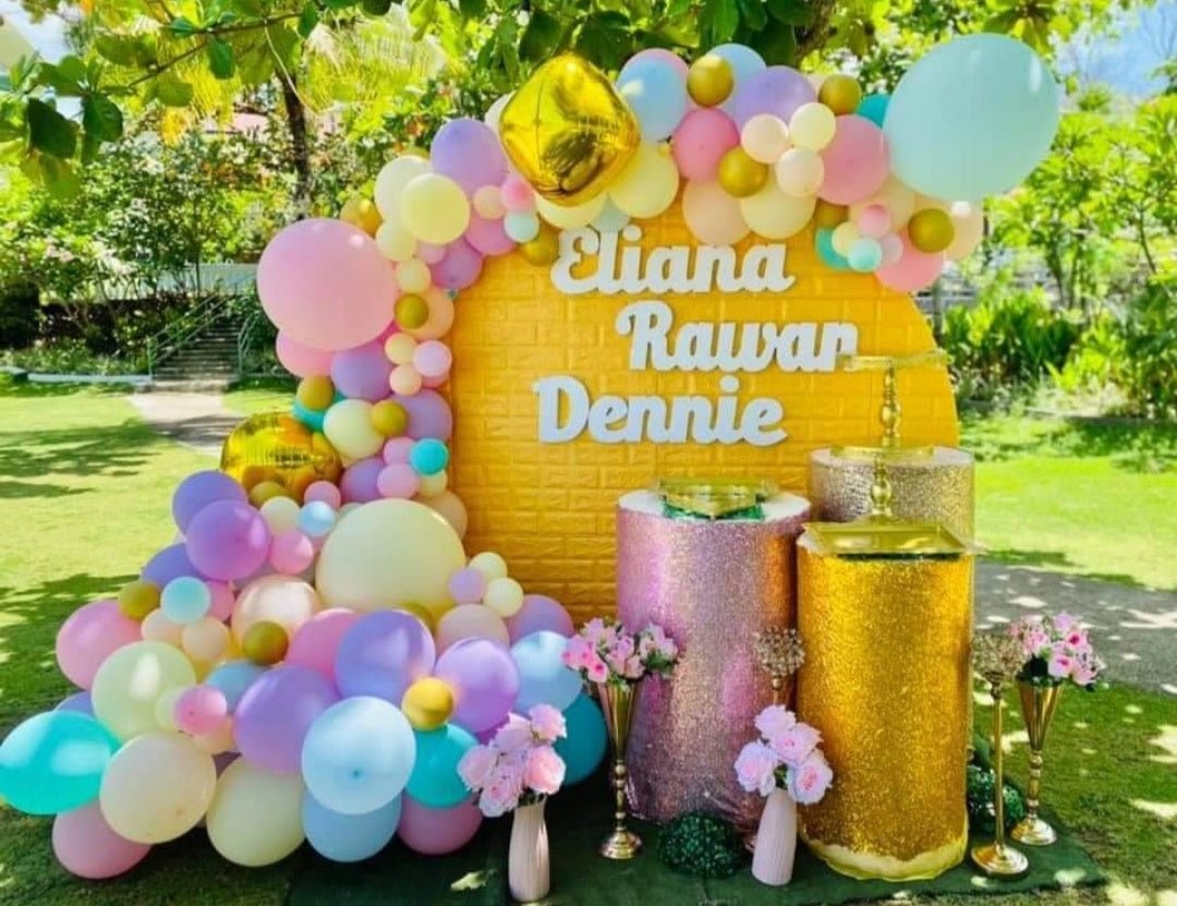 Yellow brick-patterned cake with pastel balloon arch and white gumpaste name toppers for Eliana Rawan Dennie. Yellow brick-patterned cake with pastel balloon arch and white gumpaste name toppers for Eliana Rawan Dennie.